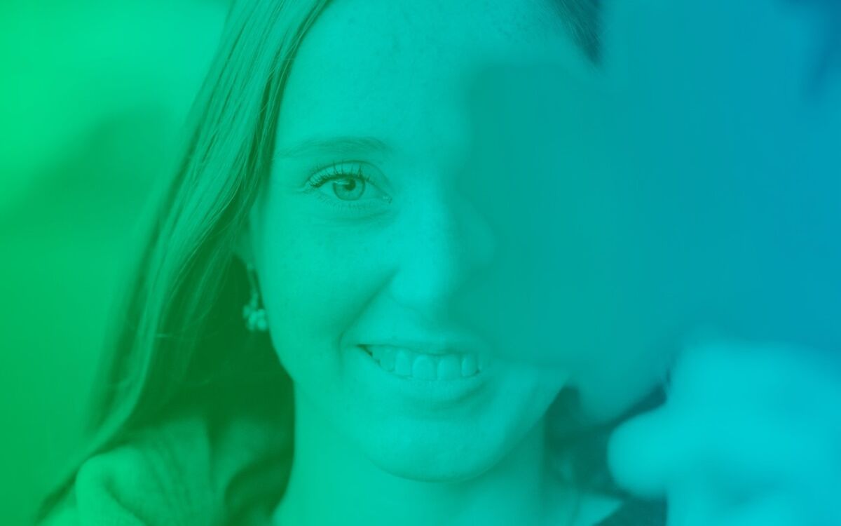 Sini-vihreäsävyinen kuva hymyilevästä naisesta