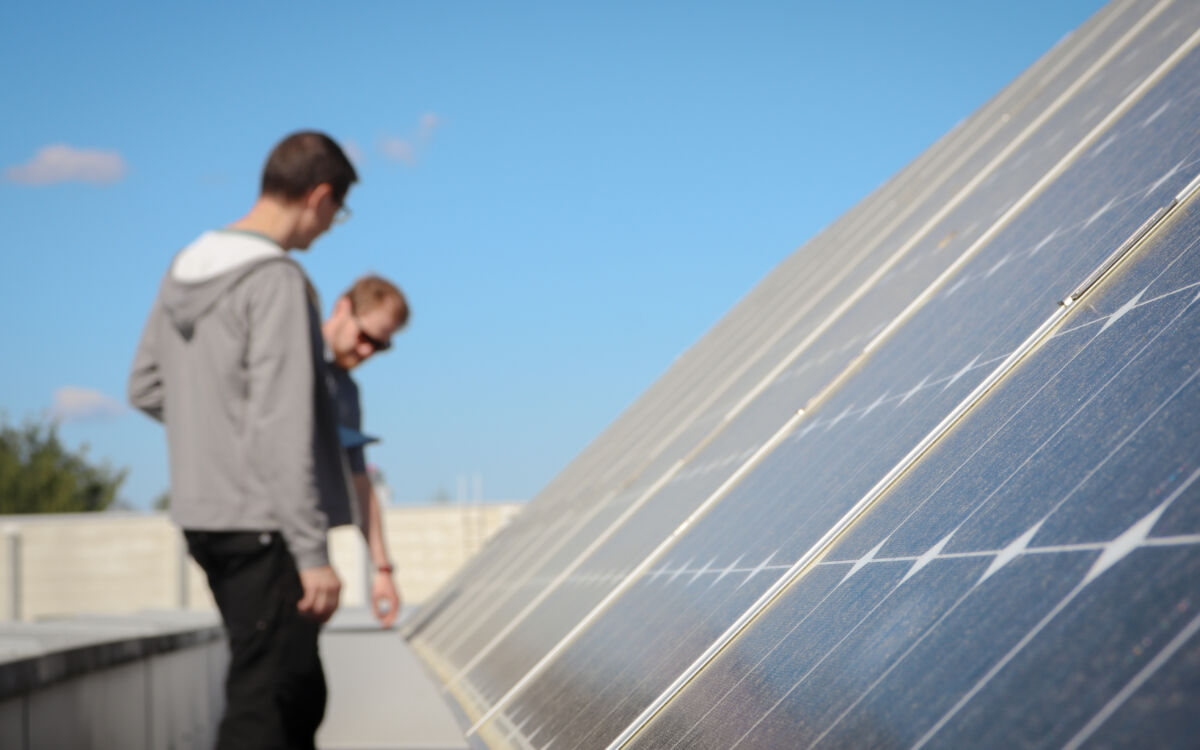 Kaksi miestä tutkii aurinkopaneeleita