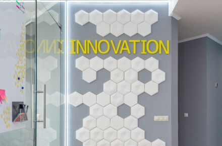 Harmaa seinä jossa valkoisia laattoja ja teksti innovation