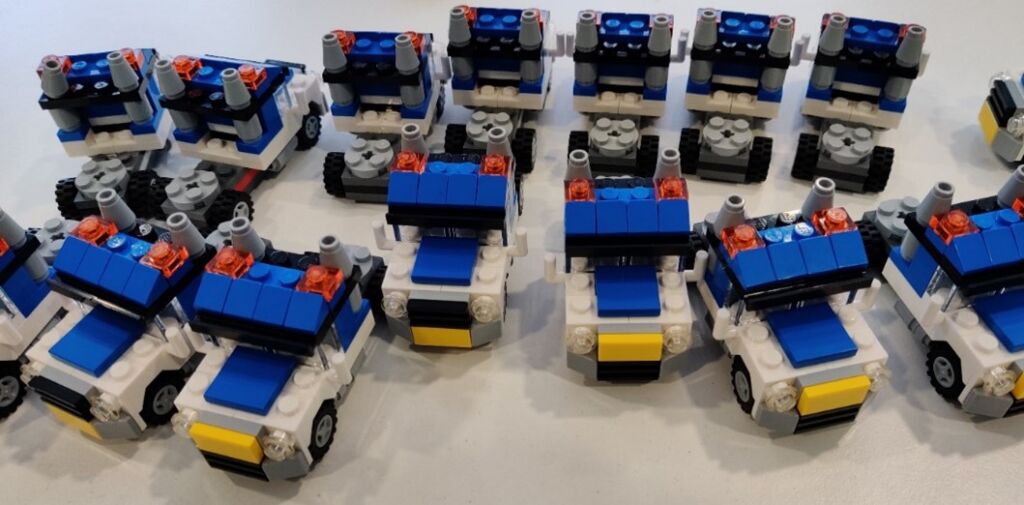 Legopalikoista rakennettuja autoja kahdessa rivissä.