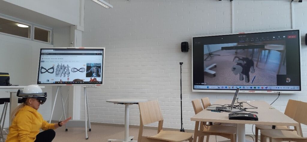 Classroom with two screens. Woman with a helmet.