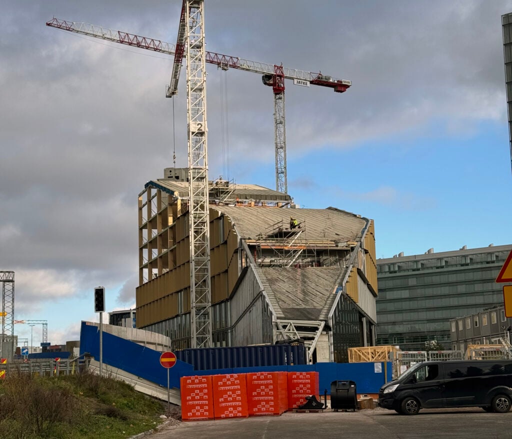 Rakennustyömaa jossa puurakenteinen rakennus, nostokurki
