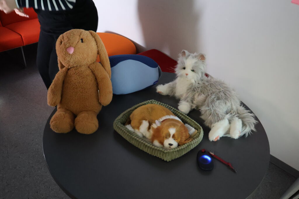 Kolme pehmolelun näköistä robottilemmikkiä: kani, koira ja kissa