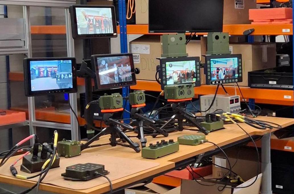 Pöydällä erilaisia lämpökameralaitteita ja niiden näyttöjä