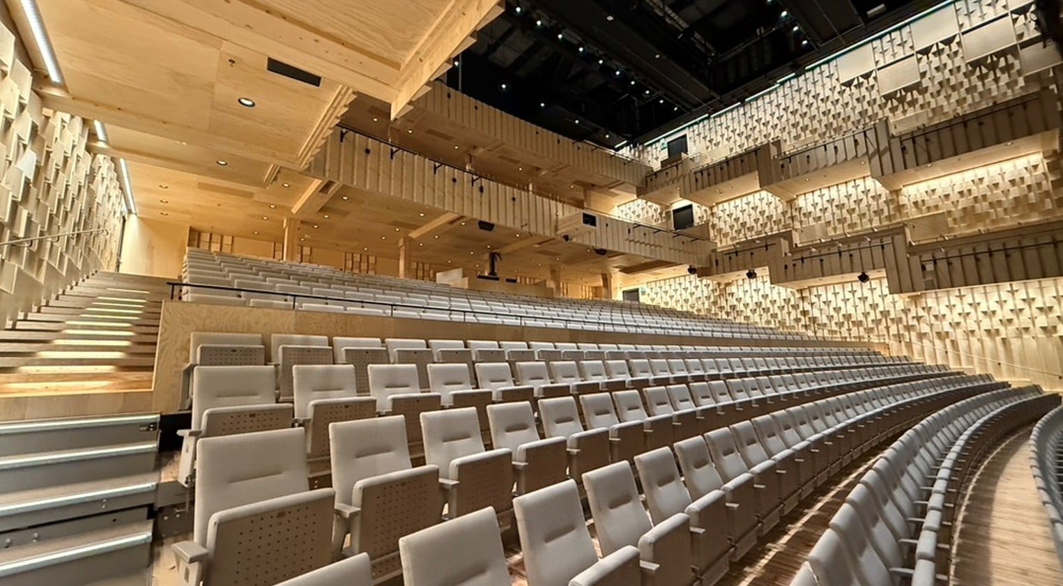 Konserttisali jossa puiset sisäseinät, penkkirivistöjä ja parvet.